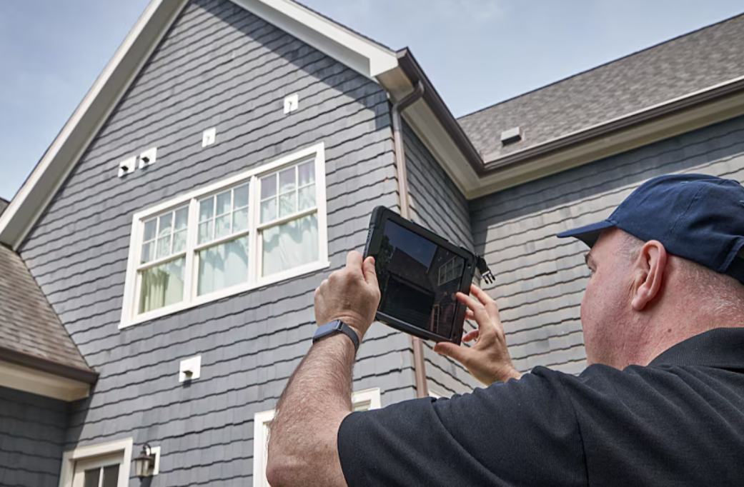 image-of-man-taking-a-picture-of-a-roof-from-the-ground-png Annual Maintenance and Roofing Tips for Every Homeowner